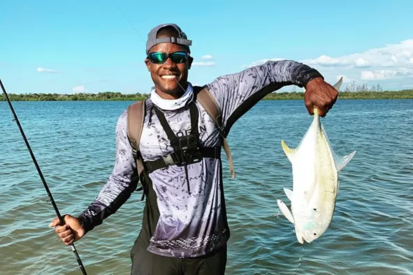 A man shows off the fish he caught while shore fishing