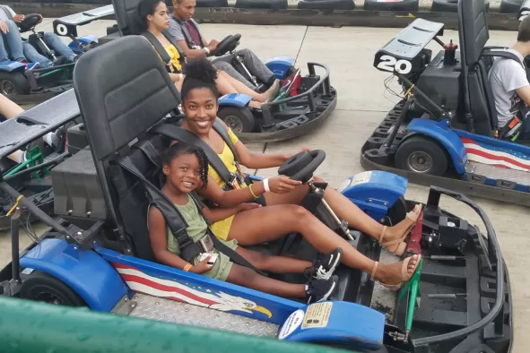 A mom and daughter enjoy a go-kart ride together