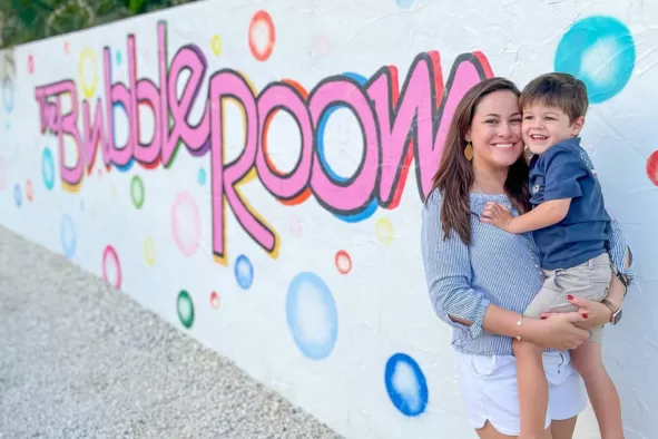 A mom and son pose for the camera at the Bubble Room