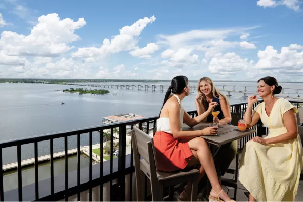 Women enjoy cocktails at a rooftop bar in the downtown Historic River District