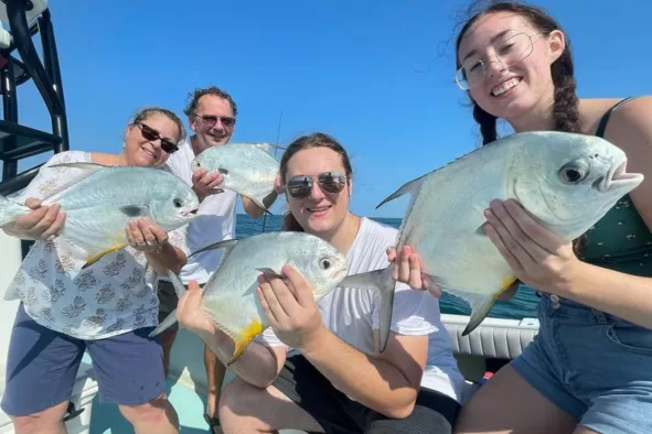 A family show off their prize catches from a deep-sea fishing adventure