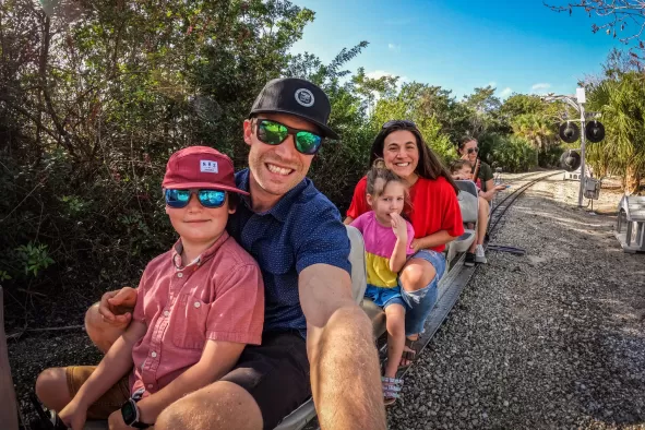 A family enjoys the miniature train ride at Lakes Park