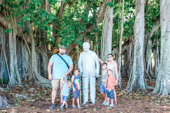 A family poses for the camera under the banyan tree at the Edison & Ford Estates