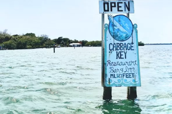A rustic sign in the water for Cabbage Key Restaurant Bar & Inn
