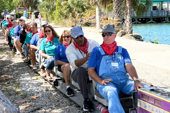 Tourism employees ride the miniature train in Lakes Park