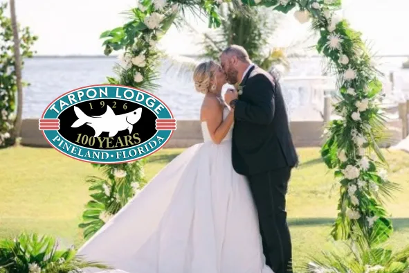 A couple kisses at their waterfront wedding ceremony at Tarpon Lodge