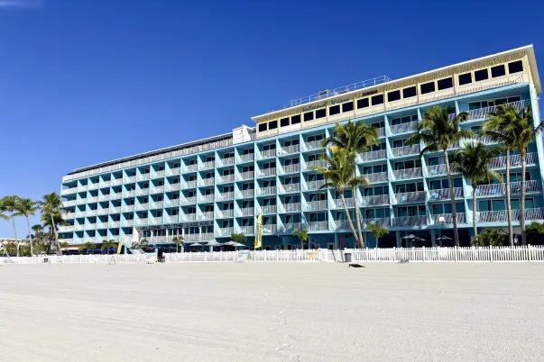 blue beachfront hotel with 6 levels, white sandy beach, palm trees