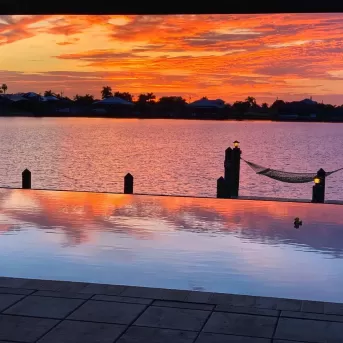 vista del atardecer con vista a la piscina y al agua