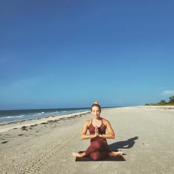 Ejercicio de yoga en la arena de la playa