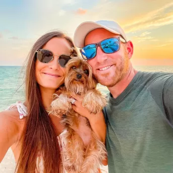 pareja con perro al atardecer