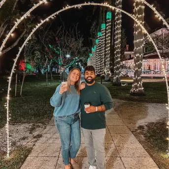 A couple poses under a lit arch at the Edison Ford Winter Estates
