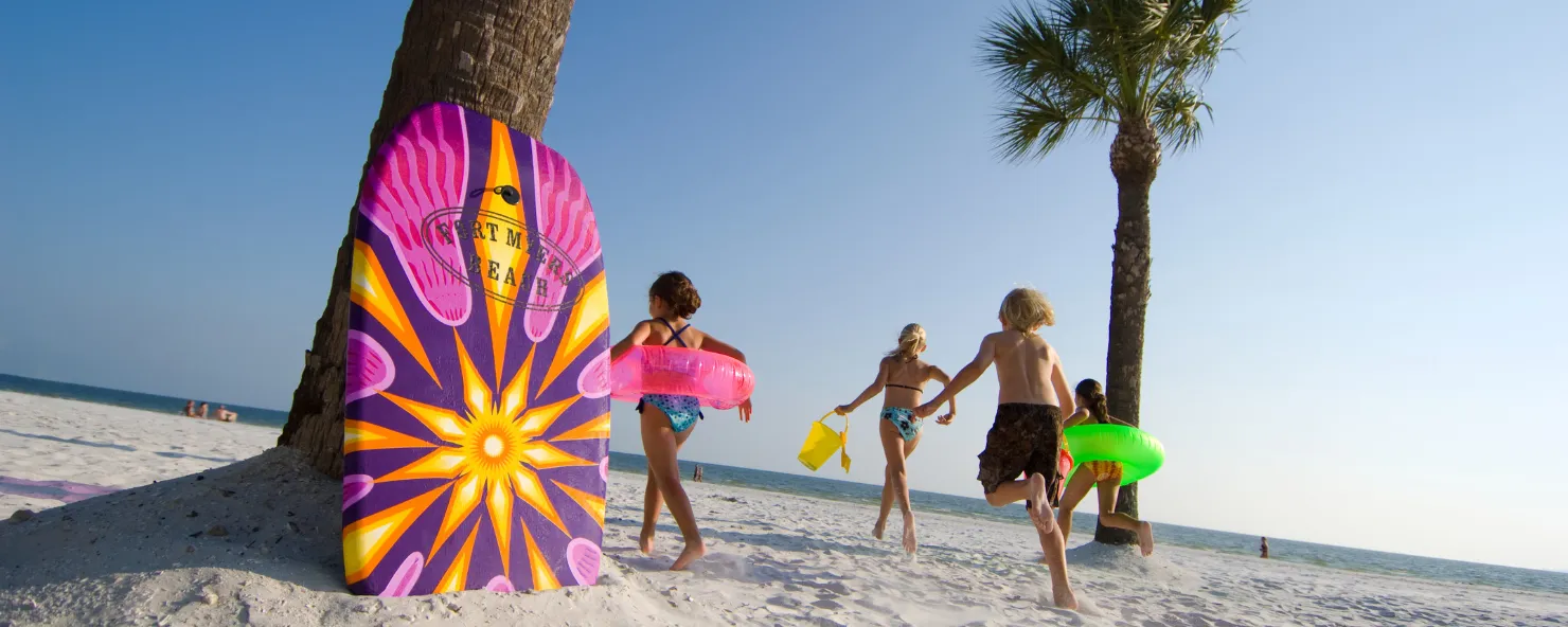 Kids run down the beach