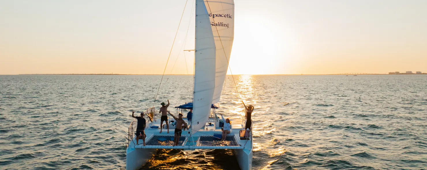 A group enjoys sailing at sunset