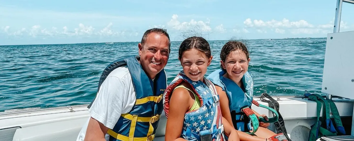 A father and his daughters enjoy boating