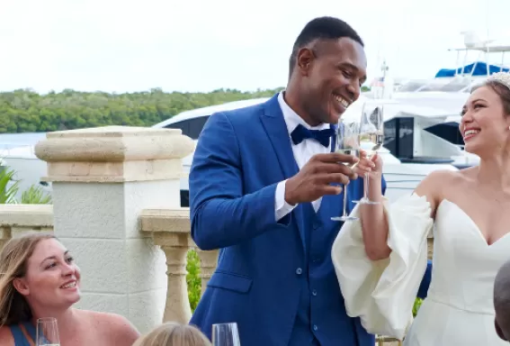 a bride and a groom share a toast with their bridal party